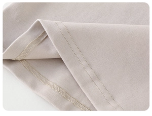 Gros plan détaillé montrant la couture à double aiguille sur l'ourlet du t-shirt en coton