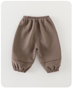 Detail of coffee-brown cotton bloomers for kids featuring elastic waist and gathered hems