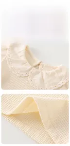 Detail of baby girl knitted long sleeve top with Peter Pan collar and eyelet embroidery
