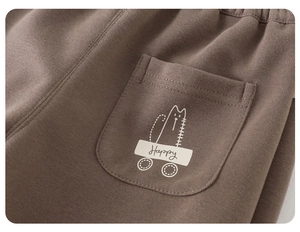 Detail of coffee brown kids cotton sweatpants featuring happy cartoon cat back pocket print