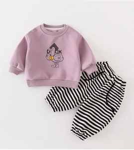 Detailed view of pink baby sweatshirt with cartoon duck and black white striped trousers