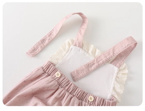 Detail of pink floral baby romper with white lace embroidery and elastic waist texture