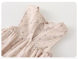 Close-up of floral baby girls' romper with wooden button and elastic neck detail