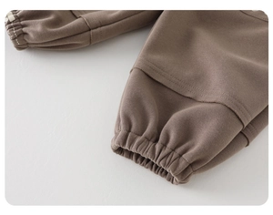 Detail of elastic ribbed cuffs and reinforced stitching on brown cotton kids joggers