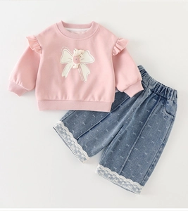 Detail view of pink girls sweatshirt with rabbit doll and bow print denim pants