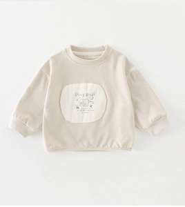 Detail of soft cotton beige sweatshirt showing a cartoon elephant patch and ribbed cuffs
