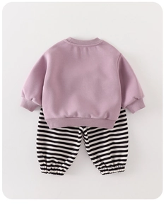Flat lay detail of purple baby sweatshirt and black striped joggers in soft cotton