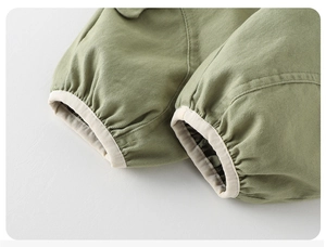 Detailed macro view of olive green twill baby pants with cream elastic ribbed cuffs