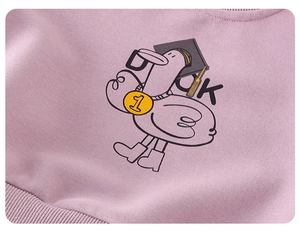Detail of baby pink sweatshirt featuring a cartoon duck print and ribbed cotton fabric
