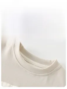 Detail view of cotton beige crew neck top showing ribbed collar and smooth inner stitching