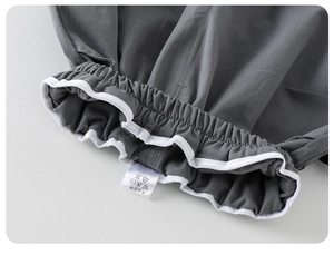 Detail of baby boy trousers featuring elastic waistband with white contrast piping