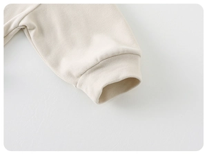 Detailed macro shot of a cream-colored ribbed cuff on a soft knitted cotton long sleeve top