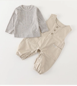 Detail of baby striped shirt and khaki overalls set with wooden buttons and snap crotch