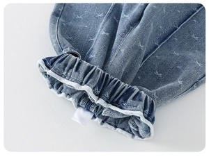 Detail of baby girl denim set featuring elastic waistband and white bow jacquard pattern