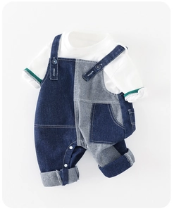 Détail de l'ensemble salopette bébé en jean avec boutons pression et poignets rayés