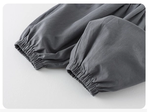 Detail view of dark grey joggers featuring elastic cuffs and cotton blend knit fabric