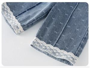 Detail view of denim pants with white lace hem and bow-knot jacquard patterns