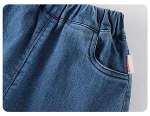 Dettaglio ravvicinato della vita elastica e dell'etichetta della tasca dei jeans da bambina