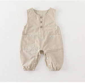 Detail of baby sleeveless cotton romper with wooden buttons and natural life patch