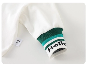 Détail du poignet en coton pour bébé avec rayures, broderie Hello et étiquette de taille 73
