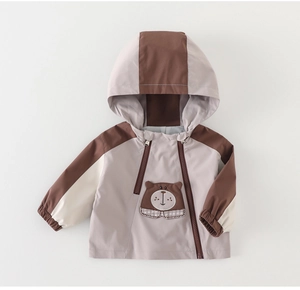 Detail of baby hooded windbreaker with bear patch and dual zipper design