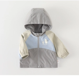 Détail de la veste coupe-vent pour garçons avec imprimé cartoon et design tricolore