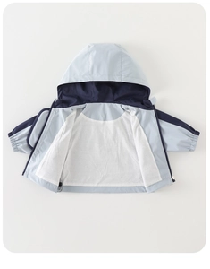 Close-up of kids hooded windbreaker featuring blue patchwork and white mesh lining