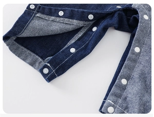Détails de la salopette en jean pour bébé avec boutons-pression blancs et coutures de finition