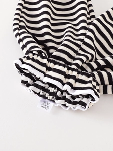 Infant two-piece knit set with black and white stripes and elastic cuffs detail