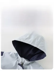 Detail of boys windproof hooded jacket with light blue and navy blue contrast design