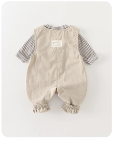 Detail view of baby beige overalls set with striped long sleeve shirt and slogan patch