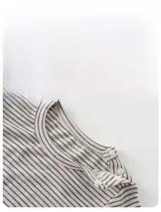 Close-up of baby striped knit top with shoulder snaps and soft cotton texture