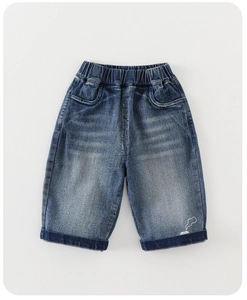 Detail of kids denim pants with elastic waist and small house print on rolled cuff