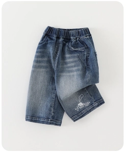 Detail of kids elastic waistband and cute white house graphic on dark blue jeans