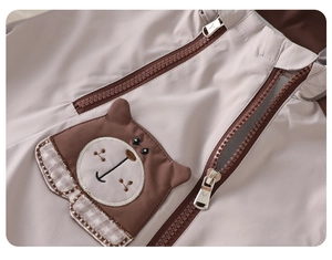 Close-up of children's jacket featuring a 3D bear pocket and double metal zippers