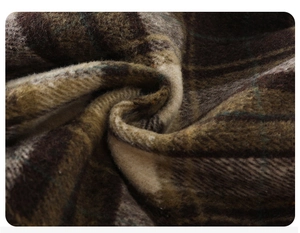 Gros plan du tissu en laine à carreaux marron montrant les fibres douces et le tissage