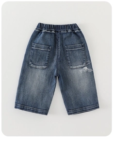 Detail of boys denim shorts with elastic waistband and white house print on dark blue fabric