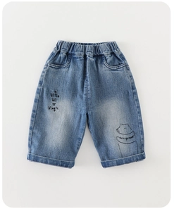 Detail view of denim shorts with elastic waistband and cute embroidered bear pattern