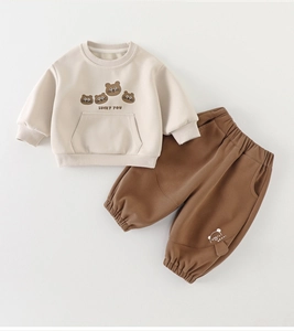 Close-up of beige toddler sweatshirt and brown pants with cute bear prints and rib cuffs