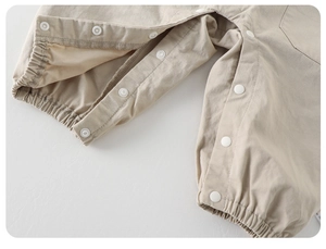 Detail of baby overalls with resin snap buttons for diaper changes and elastic leg cuffs