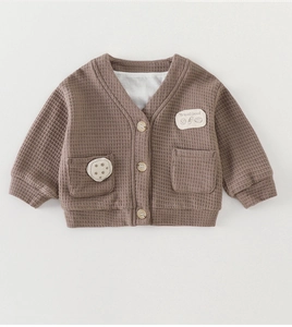Dettaglio ravvicinato del cardigan per neonati in maglia a nido d'ape marrone con scollo a V