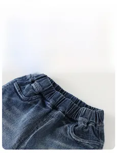 Detail view of boys' blue denim pants featuring elastic waistband and functional pockets