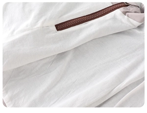 Detailed close-up of dark brown resin zipper and grey technical fabric stitching on jacket