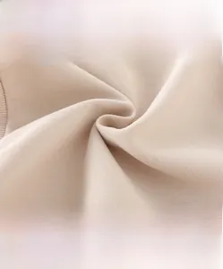 Close-up of beige high-density knit fabric showing soft texture for kids sweatshirt