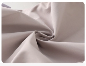 Macro detail of soft morandi pink woven fabric showing smooth texture and drape