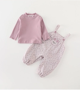 Detail of pink long sleeve top with ruffle cuffs and floral bunny overalls set