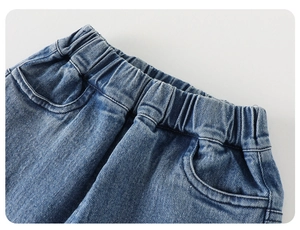Detailed close-up of elastic waistband and front pockets on boys' blue denim jeans
