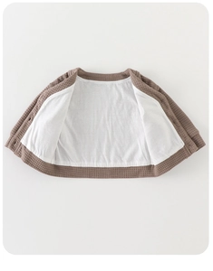 Dettaglio del cardigan per bambini a nido d'ape con fodera interna bianca morbida