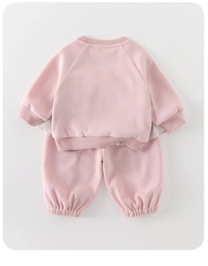 Detailed close-up of pink striped knit sweater and joggers set with ribbed cuffs