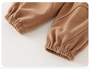 Detail of baby brown jogger pants showing elastic cuffs and soft knit cotton fabric